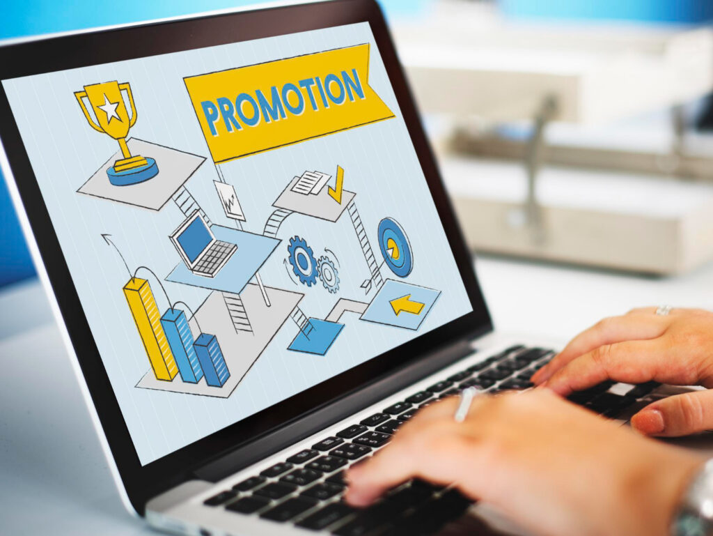 Persona trabajando en un ordenador con una pantalla sobre promociones digitales, representando cómo crear campañas online para aumentar ventas.